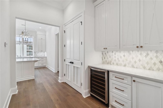 bar with wine cooler, white cabinets, tasteful backsplash, and dark wood-type flooring