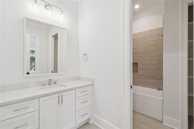 bathroom featuring hardwood / wood-style floors, vanity, and tiled shower / bath combo