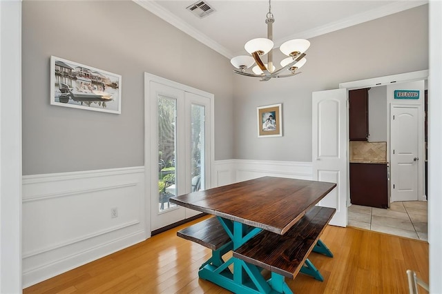 dining space with a chandelier, light hardwood / wood-style floors, and ornamental molding