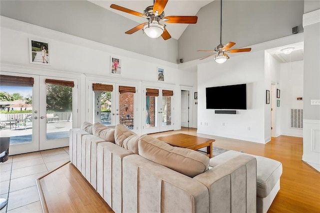 tiled living room featuring french doors, high vaulted ceiling, and ceiling fan