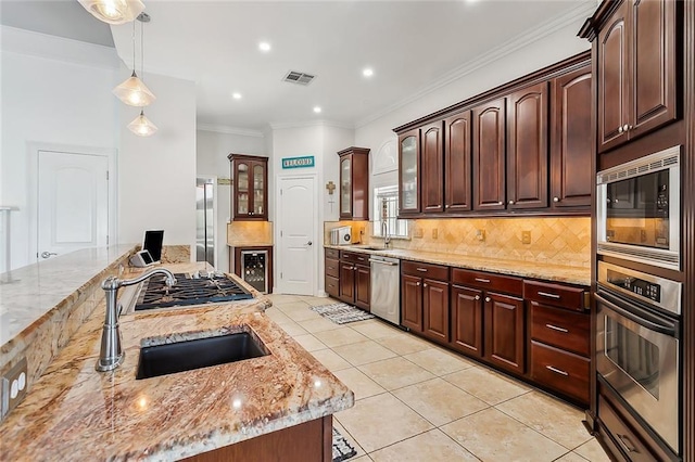 kitchen with light stone countertops, pendant lighting, and stainless steel appliances