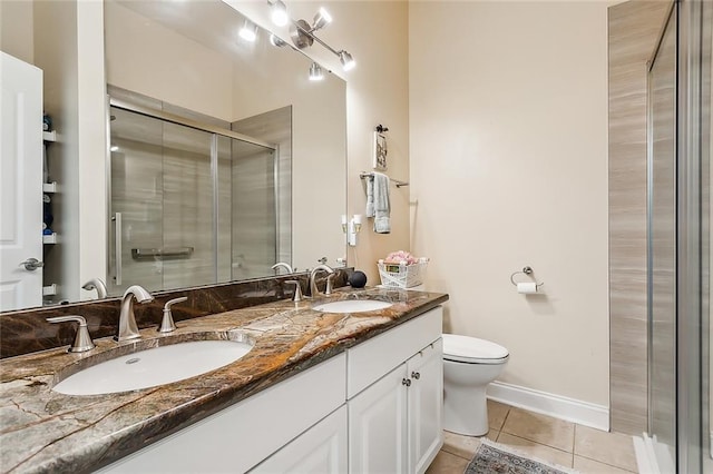 bathroom featuring tile patterned flooring, vanity, toilet, and an enclosed shower