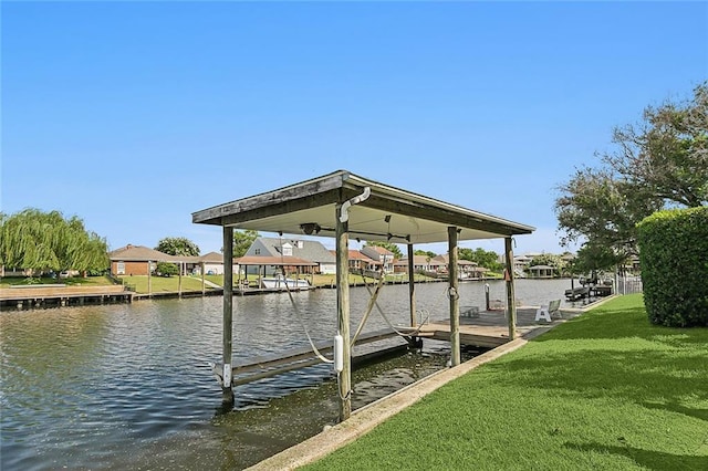 dock area with a lawn and a water view