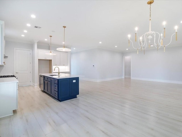 kitchen featuring sink, blue cabinets, crown molding, decorative light fixtures, and white cabinets