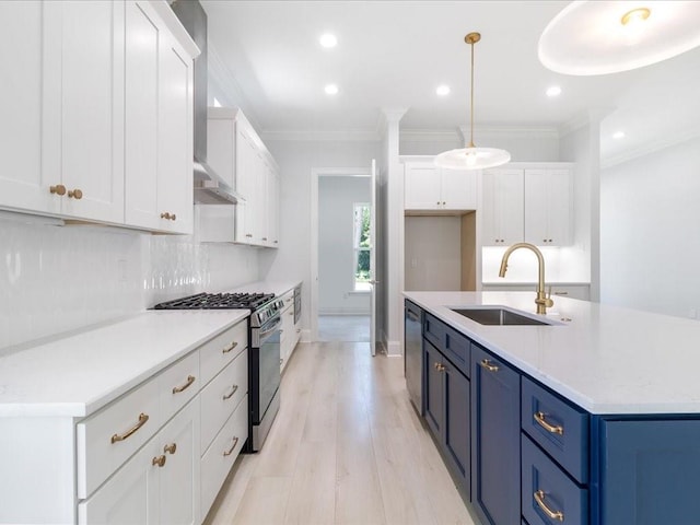 kitchen with appliances with stainless steel finishes, white cabinetry, blue cabinets, and sink