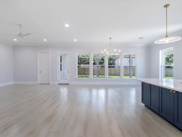 unfurnished living room with plenty of natural light, light hardwood / wood-style floors, and ceiling fan with notable chandelier