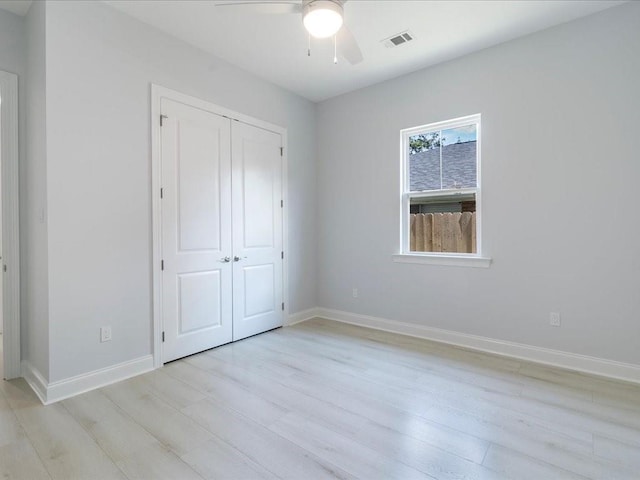 unfurnished bedroom with ceiling fan, a closet, and light hardwood / wood-style floors