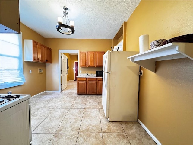 kitchen featuring hanging light fixtures, a notable chandelier, a textured ceiling, white appliances, and light tile patterned flooring