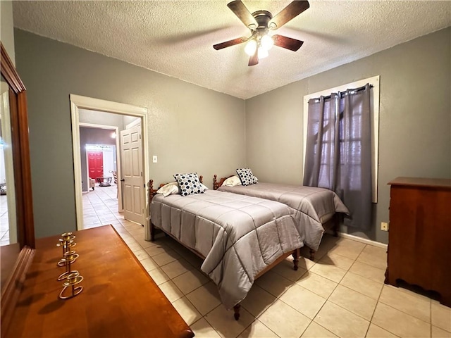 tiled bedroom featuring ceiling fan and a textured ceiling