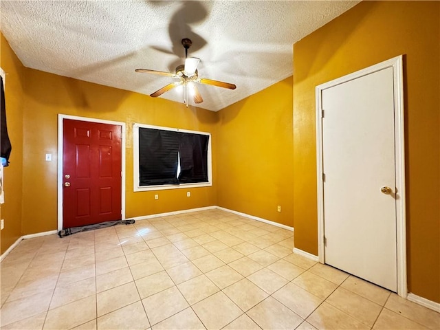 unfurnished living room with ceiling fan, light tile patterned floors, and a textured ceiling