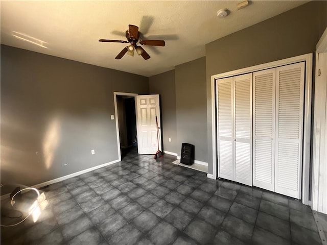 unfurnished bedroom featuring ceiling fan and a closet