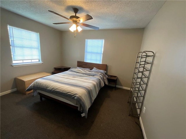 bedroom with multiple windows, ceiling fan, and dark carpet