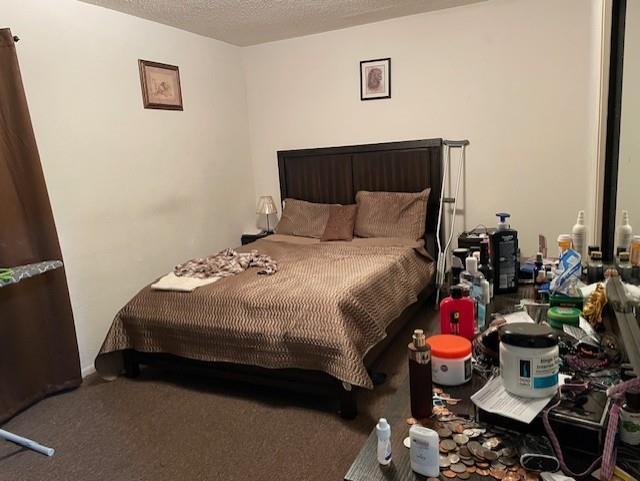 carpeted bedroom featuring a textured ceiling