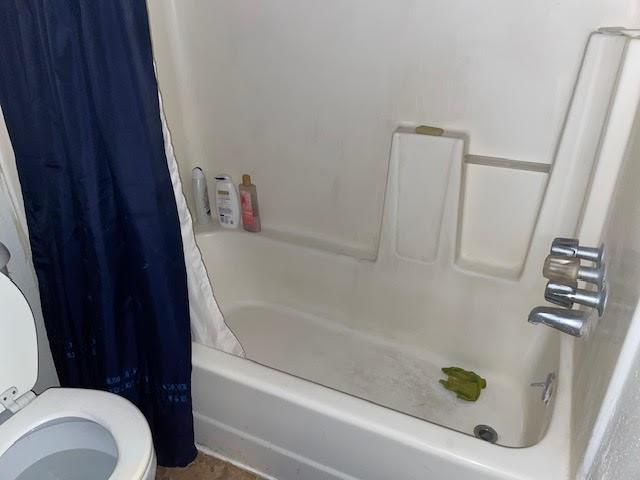 bathroom with shower / tub combo and toilet