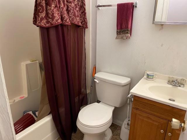 full bathroom featuring vanity, shower / tub combo, tile patterned flooring, and toilet