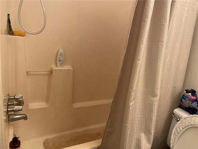 bathroom featuring toilet and shower / tub combo with curtain