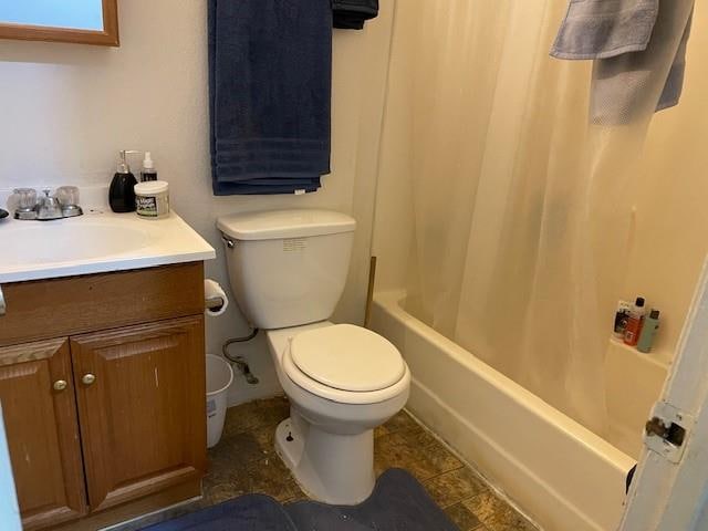 full bathroom with shower / tub combo with curtain, vanity, tile patterned flooring, and toilet