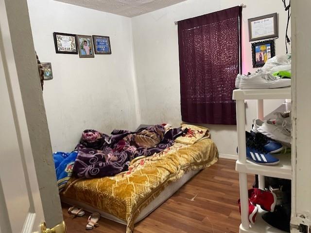 bedroom featuring a textured ceiling and wood-type flooring