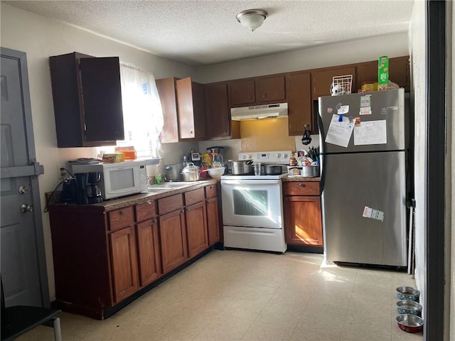 kitchen featuring stainless steel fridge, white range with electric cooktop, light tile patterned floors, and a textured ceiling