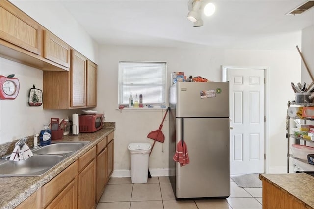 kitchen featuring light tile patterned floors, stainless steel appliances, and sink