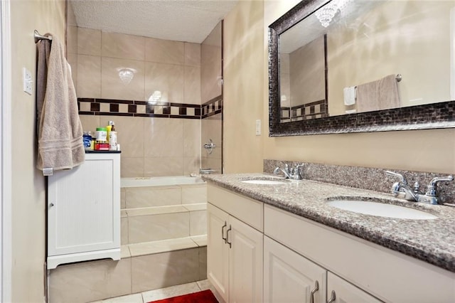 bathroom featuring a textured ceiling, vanity, and tile patterned floors