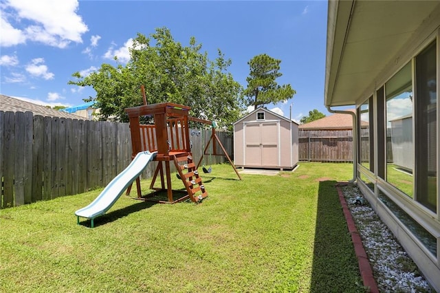 view of play area featuring a lawn and a shed