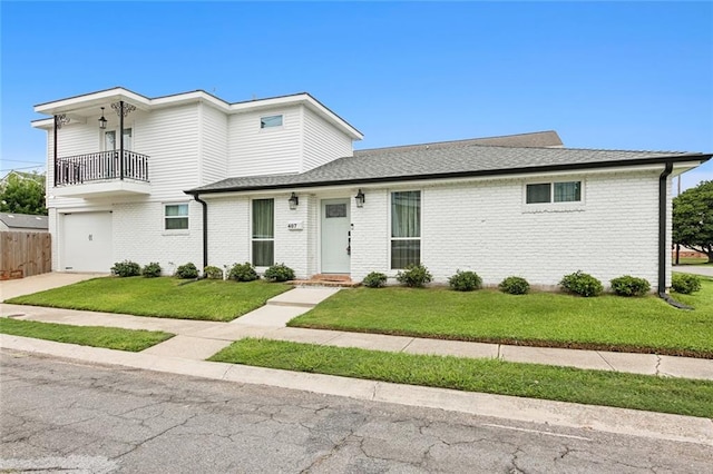 view of front of house featuring a garage, a balcony, and a front yard