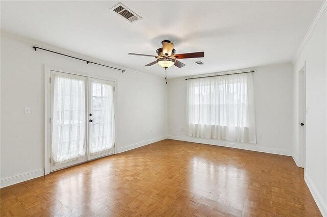 empty room featuring light parquet floors, ceiling fan, french doors, and crown molding