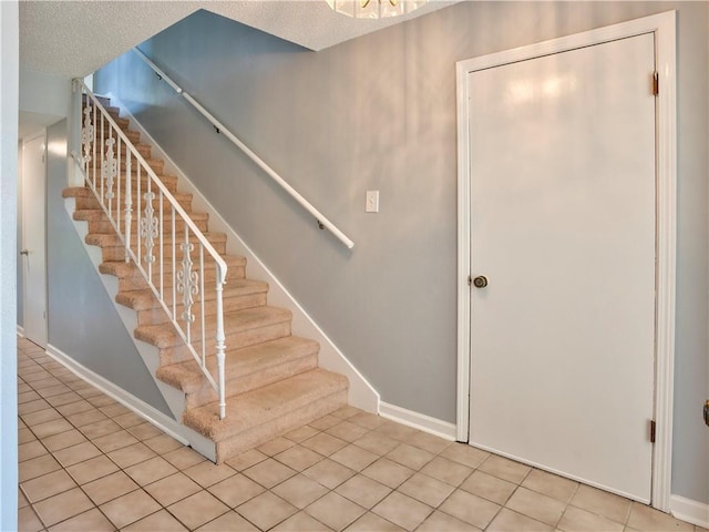 staircase featuring tile patterned floors and a textured ceiling