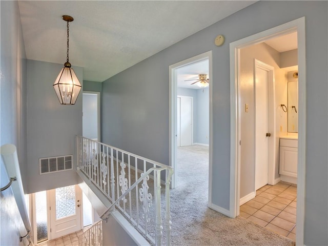 hall with light colored carpet