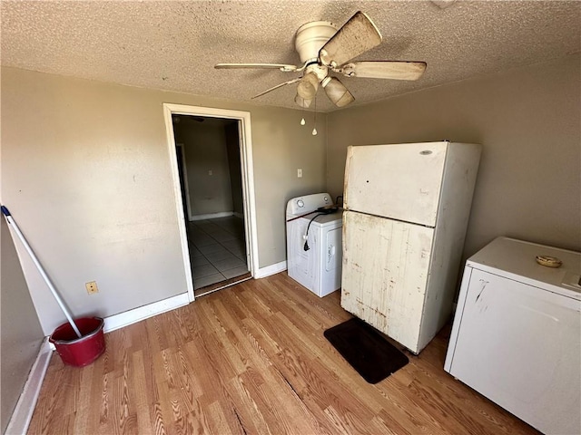 laundry area featuring ceiling fan, light hardwood / wood-style floors, a textured ceiling, and washer / clothes dryer