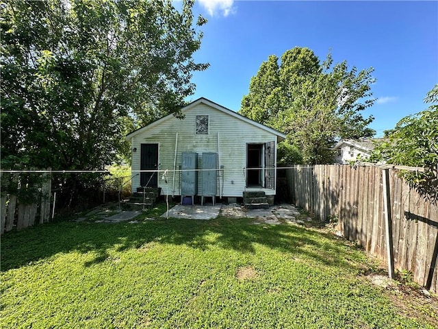 rear view of house featuring a yard