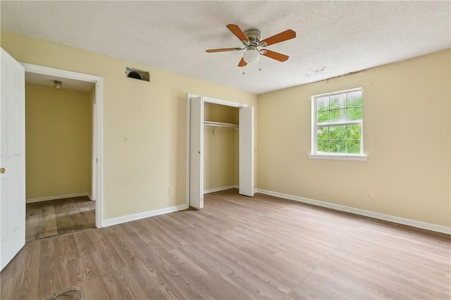 unfurnished bedroom featuring a textured ceiling, ceiling fan, and light wood-type flooring