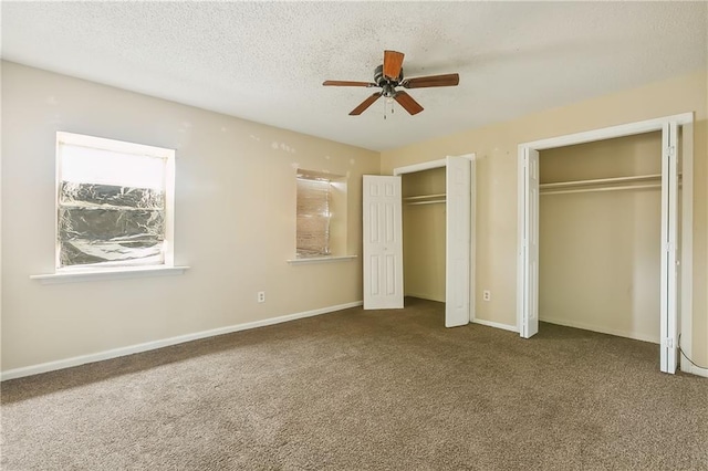 unfurnished bedroom with multiple closets, ceiling fan, and carpet flooring