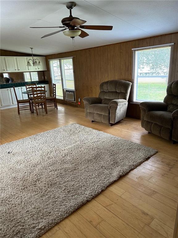 living room featuring ceiling fan, light wood-type flooring, and cooling unit