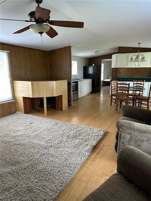 living room with sink, ceiling fan, and light wood-type flooring