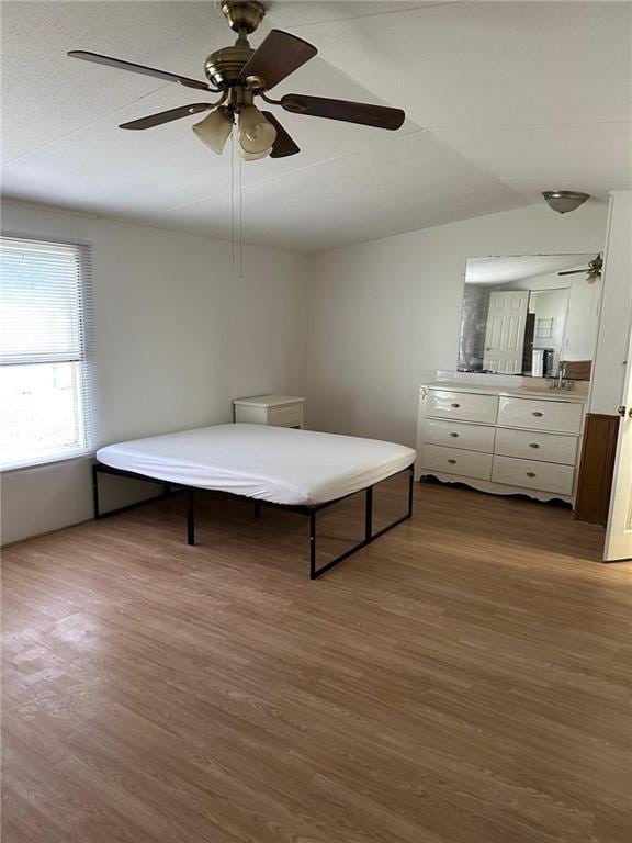 unfurnished bedroom with ceiling fan and wood-type flooring