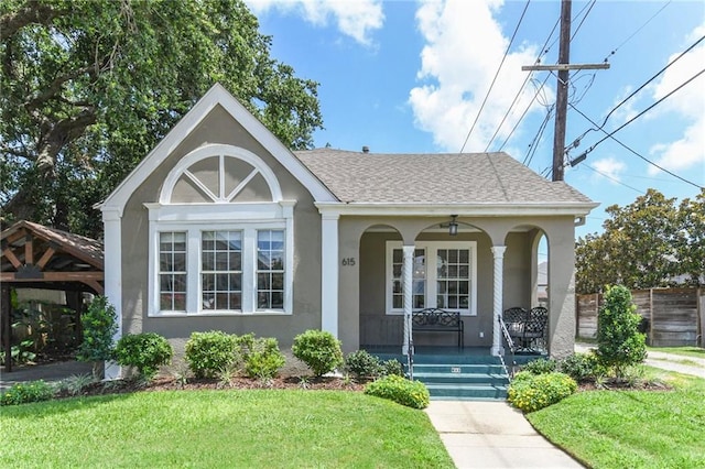 view of front of house featuring a carport, covered porch, and a front lawn