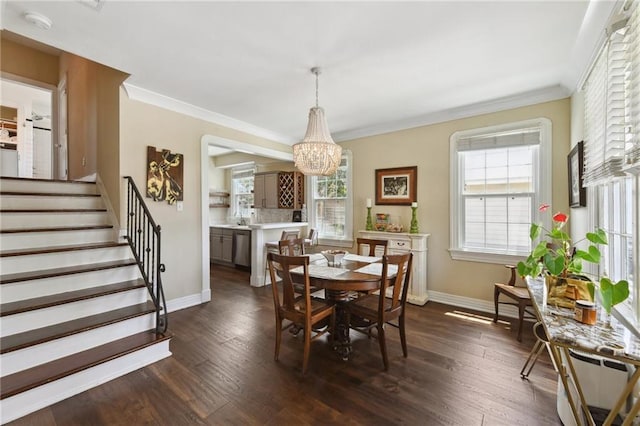 dining room featuring dark wood-type flooring, ornamental molding, and a chandelier