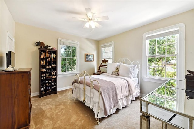 carpeted bedroom with multiple windows and ceiling fan