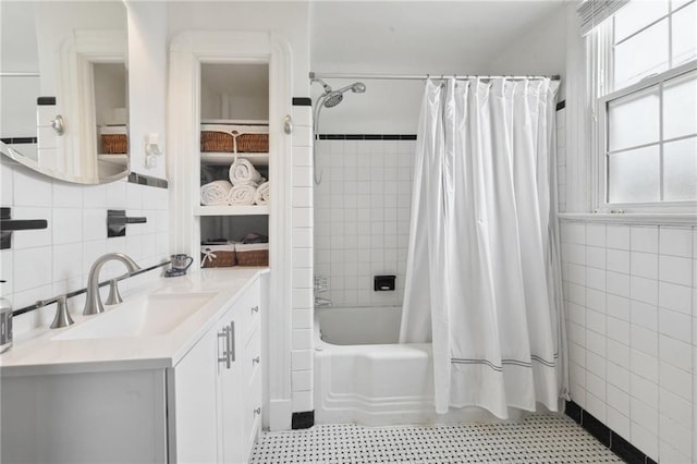 bathroom with vanity, tile walls, and shower / tub combo