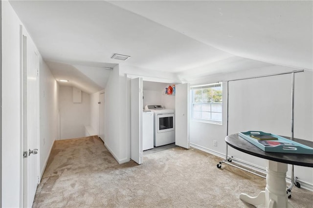 interior space featuring vaulted ceiling, light colored carpet, and washing machine and clothes dryer