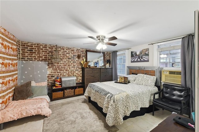 bedroom with cooling unit, ceiling fan, and brick wall