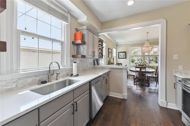 kitchen with sink, gray cabinetry, decorative light fixtures, stainless steel appliances, and backsplash