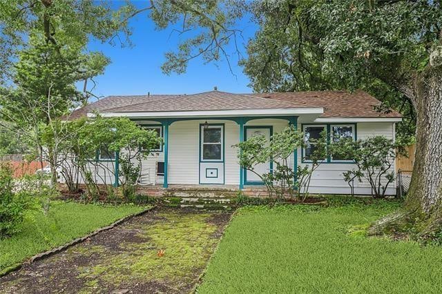 single story home featuring a porch and a front lawn