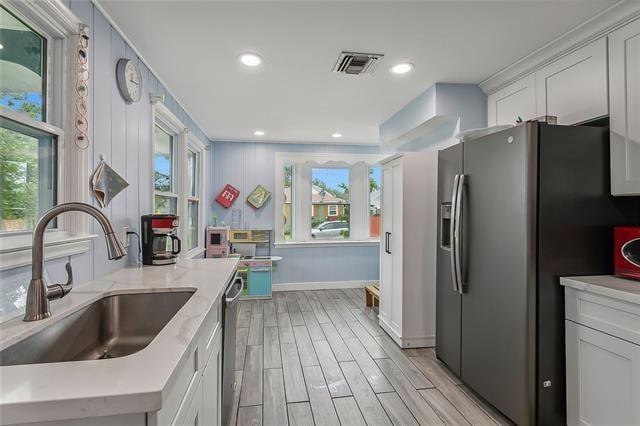 kitchen with a healthy amount of sunlight, appliances with stainless steel finishes, sink, and light hardwood / wood-style flooring