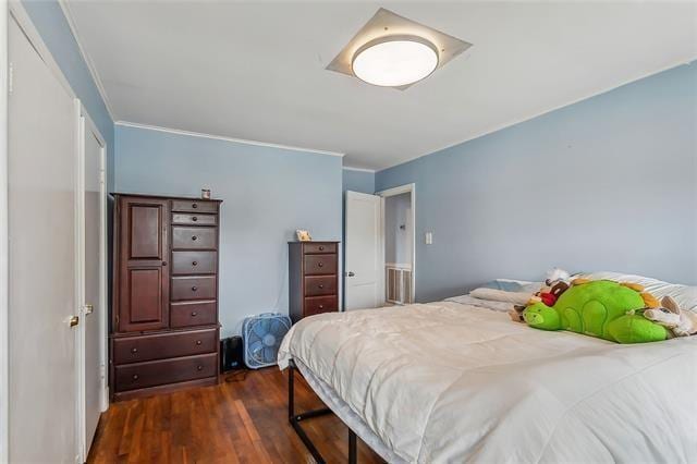 bedroom with dark wood-type flooring and ornamental molding