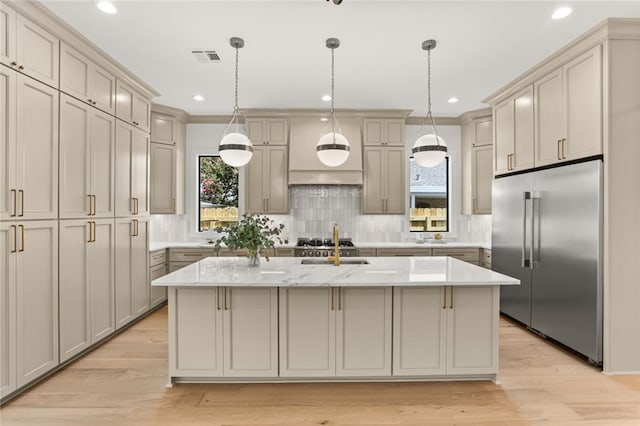 kitchen featuring tasteful backsplash, gray cabinetry, a kitchen island with sink, and appliances with stainless steel finishes