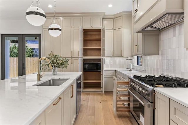 kitchen featuring sink, premium range hood, light hardwood / wood-style floors, cream cabinetry, and high end stainless steel range