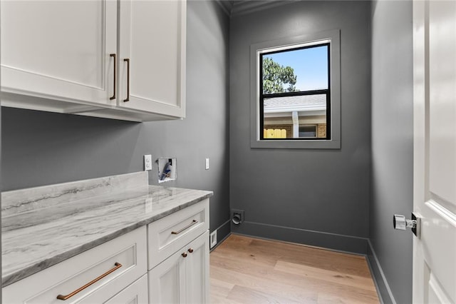 laundry room featuring cabinets, hookup for a washing machine, and light hardwood / wood-style flooring